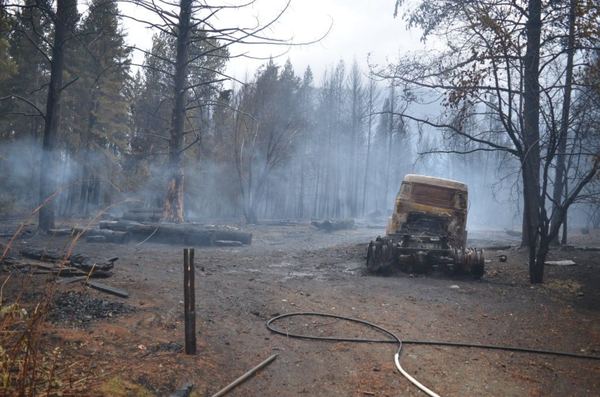 Restos humeantes de una construcción tras el paso del fuego en la Comarca Andina