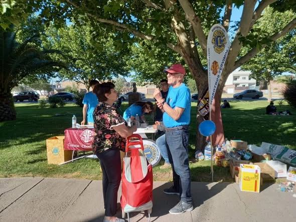 Mesa del Club Leo con equipos de medición de glucemia y folletería, atendida por jóvenes con remeras azules